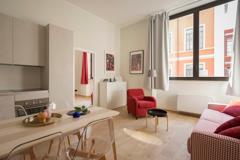 Bright apartment living room with a red chair
