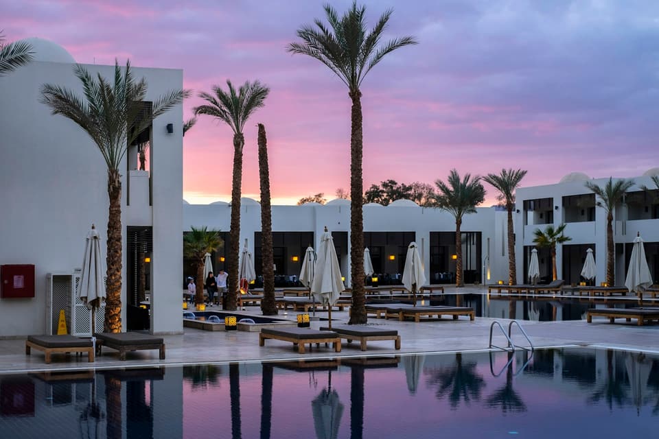 Hotel exterior with palm trees at sunset